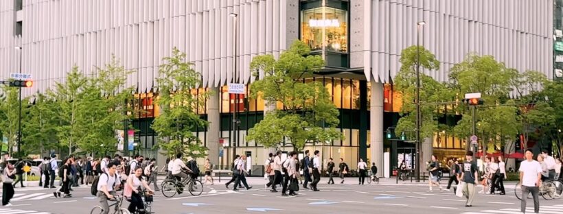 梅田街頭的大路口，行人和腳踏車正在過馬路